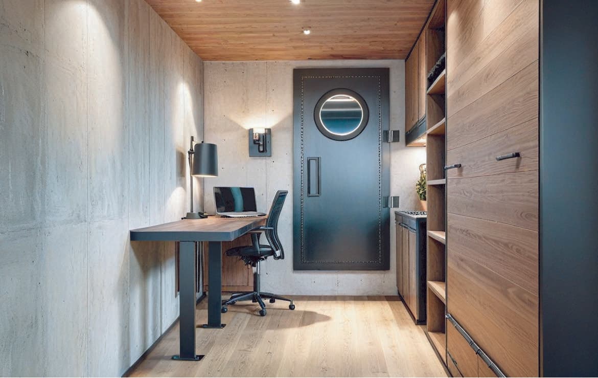 Custom CBRN-rated underground bunker interior featuring a reinforced watertight access door with circular porthole